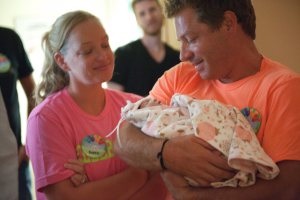 Luke carrying his niece Sophie, a baby with anencephaly